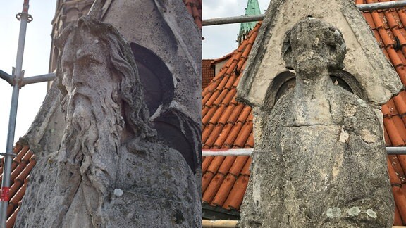 Zwei alte Statuen aus Stein: eine bildet einen langhaarigen, bärtigen Mann ab, eine zweite ist so stark verwittert, dass das Gesicht nicht mehr zu erkennen ist