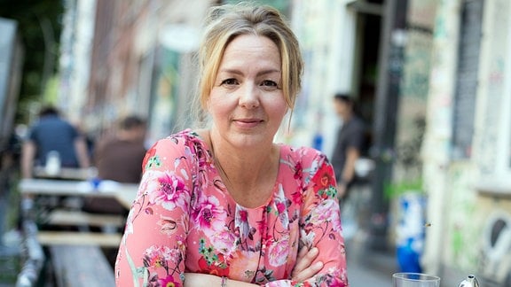 Schriftstellerin Simone Buchholz, in einem Straßencafe sitzend