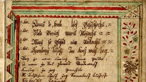 Blick auf ein historisches Schriftstück mit verzierten Rändern.