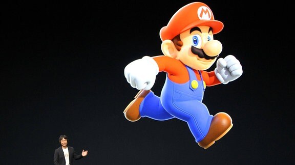 Übergroße Figur des Super Mario auf einer Bühne, daneben Shigeru Miyamoto, Erfinder des Super Mario.