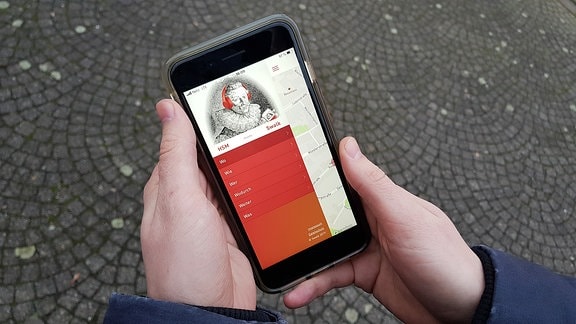Auf einem Smartphone ist eine App mit dem Portrait des Komponisten Heinrich Schütz zu sehen