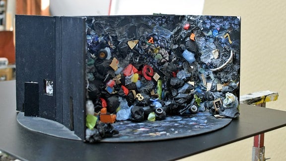 Ein kleines Modell von einer Bühne mit zahllosen schwarzen Müllsäcken.