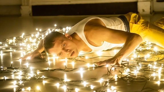 Ein Mann auf dem Boden mit Lichterketten.
