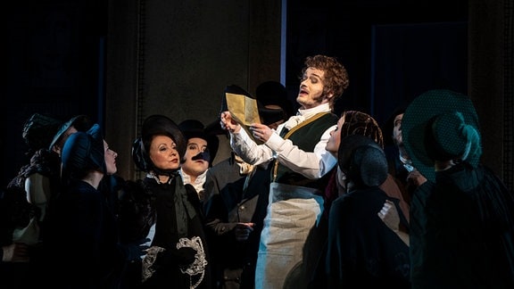 Szenenbild aus de Stück "Redoute in Reuss" am Theater Altenburg Gera, ein Mann hält ein Stück Papier in der Hand und scheint es vorzulesen