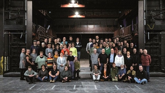 Das Team des Theatres der Altmark steht für eine Gruppenphoto auf der Bühne. 