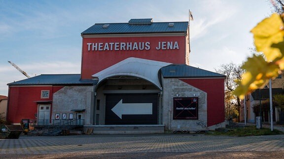Blick auf ein rotes Gebäude mit der Aufschrift Theaterhaus Jena