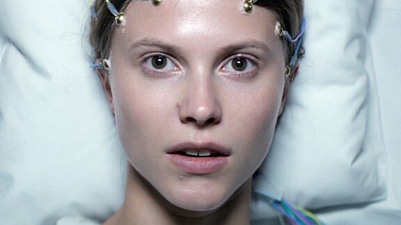 Szene aus dem Film "Thelma" - Poträt einer jungen Frau mit Elektroden am Kopf