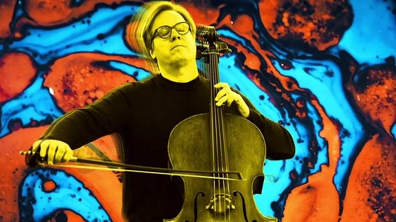 Cellist Jan Vogler vor einem bunten Hintergrund