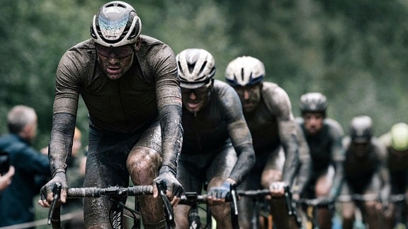 Radsportteam, verschlammt, beim Rennen Paris - Roubaix