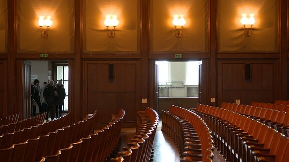 Der große Saal des Kulturpalastes Bitterfeld mit mehreren Stuhlreihen und geöffneten Türen im Hintergrund. 