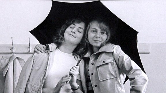 Zwei junge Frauen unter einem Schirm