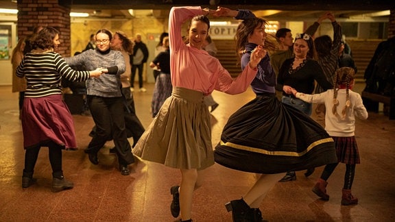 Tanzende Frauen in einer U-Bahnstation.