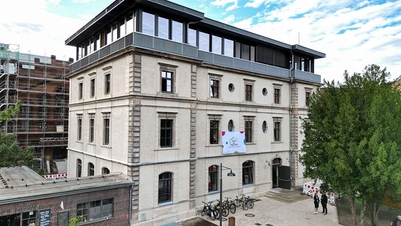 Blick auf die Villa der Kulturen in Dresden, ein dreistöckiges Gebäude mit heller Fassade.