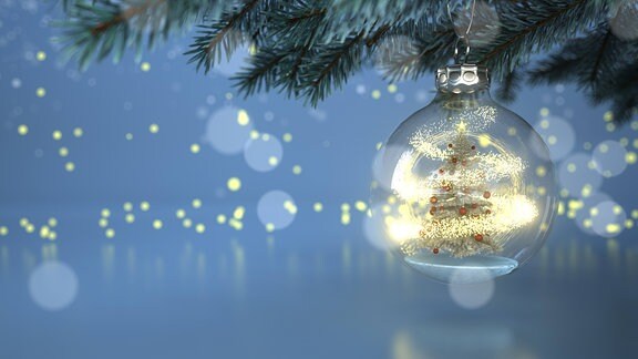Eine Weihnachtskugel hängt an einem Christbaum.