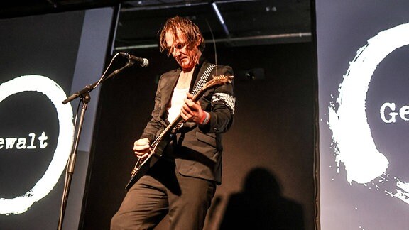 Der Gitarrist auf der Bühne bei einem Konzert von Gewalt.