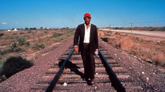 Ein Mann läuft auf Eisenbahnschwellen auf die Kamera zu in: "Paris, Texas", Spielfilm, Deutschland/Frankreich/Großbritannien 1984, Regie: Wim Wenders, Darsteller: Dean Stanton