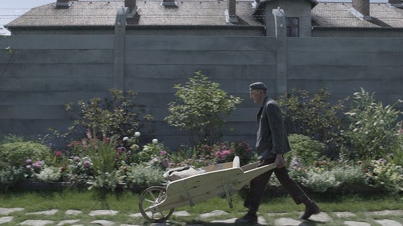 Ein KZ-Häftling erledigt Arbeiten im Garten der Familie Höss.