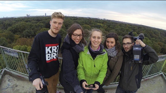 Jugendliche stehen auf dem Aussichtsturm im Leipziger Rosental
