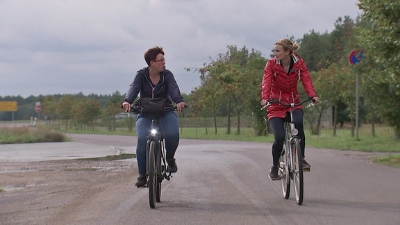 Zwei Frauen auf Fahrrädern.