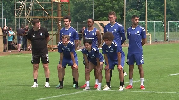 Trainer und einige Spieler des FC Magdeburgs posieren für eine Foto.