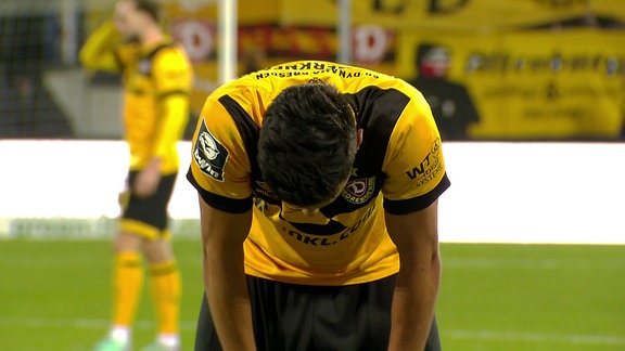 Ein Spieler von Dynamo Dresden stützt sich auf sein Knie und lässt den Kopf hängen.