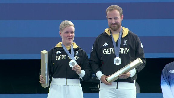 Kroppen und Unruh mit iher Silbermedaille im Bogenschießen auf dem Podest bei den Olympischen spielen von Paris