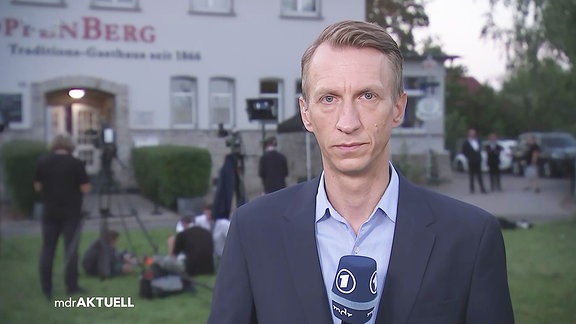 der Reporter vor einem Haus