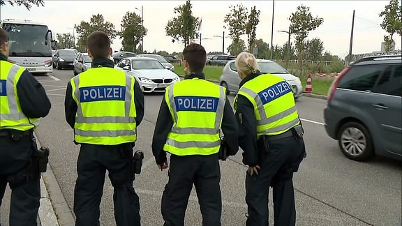 Polizist*innen stehen an einer Straße