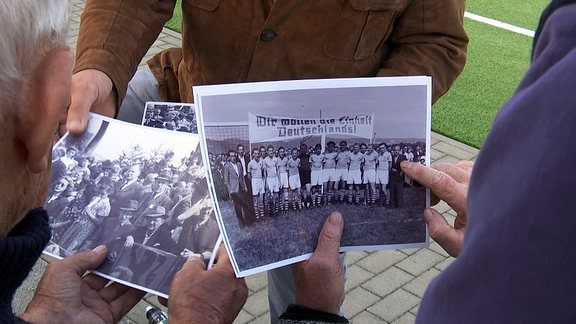 Personen betrachten alte Fotos