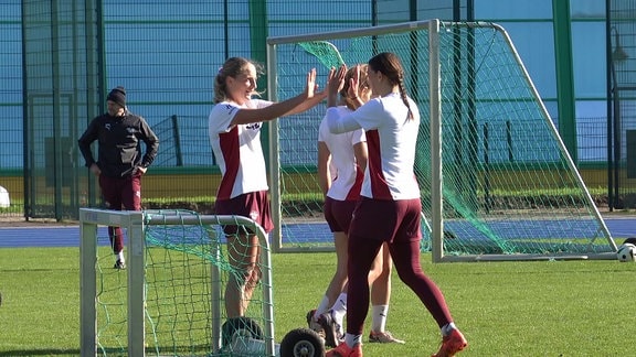 Giovanna Hoffmann klatscht sich mit Mannschaftskolleginnen beim Training ab