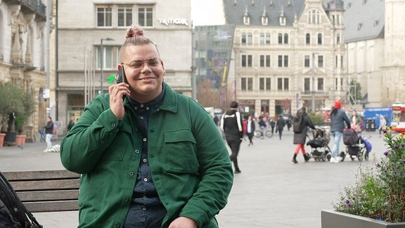 Eine Person auf einer Bank telefoniert und lächelt