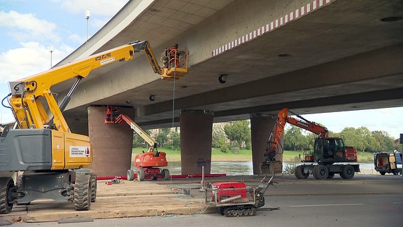 Bagger und Kräne an einer Brücke