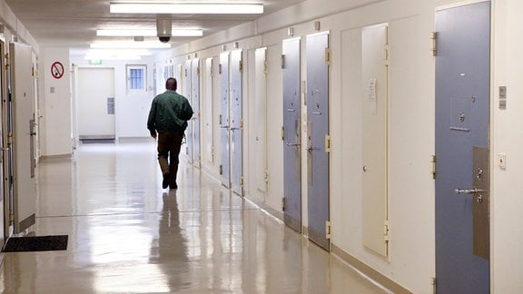 Ein Bediensteter der Justizvollzugsanstalt Tonna geht in einem Gefängnisflur an den Hafträumen vorbei. Die JVA Tonna verfügt über insgesamt 589 Haftplätze, davon sechzig im Offenen Vollzug.