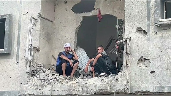 Zwei Männer sitzen in einer Ruine