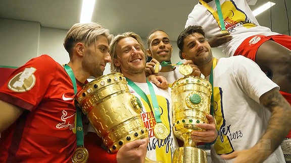 RB-Spieler, in der Mitte Emil Forsberg, präsentieren Pokale und Medaillen.