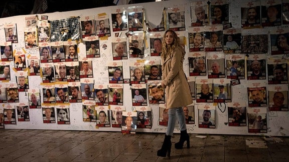 Eine Frau besichtigt eine Ausstellung mit Postern von Menschen, die am 7. Oktober 2023 von der Hamas als Geiseln genommen wurden