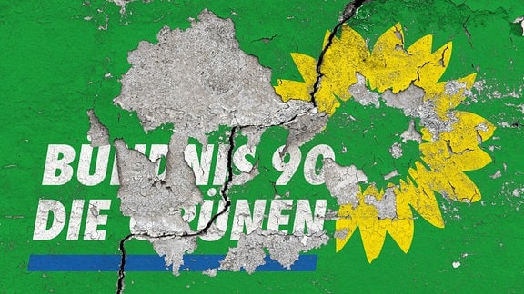 Das Logo der Partei Bündnis 90/Die Grünen auf einer Wand mit abgeplatzter und rissiger Wandfarbe und einem großen Riss in der Wand. 
