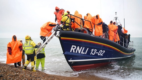 Eine Gruppe von Menschen, bei denen es sich vermutlich um Migranten handelt, wird nach Dungeness gebracht, nachdem sie von der Royal National Lifeboat Insitution (RNLI) nach einem Zwischenfall mit einem kleinen Boot im Ärmelkanal gerettet wurden.