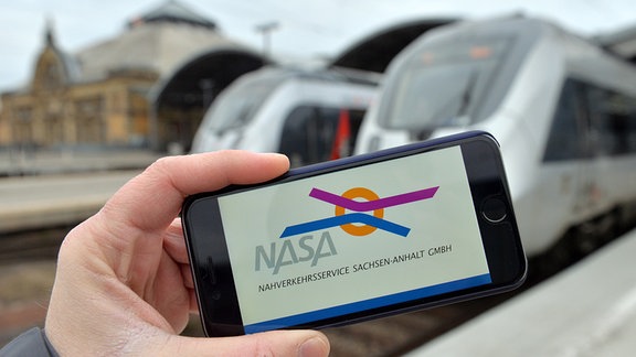 Das Logo der Nahverkehrsservice Sachsen-Anhalt GmbH (Nasa) ist im Hauptbahnhof in Halle/Saale (Sachsen-Anhalt) auf einem Smartphone zu sehen.