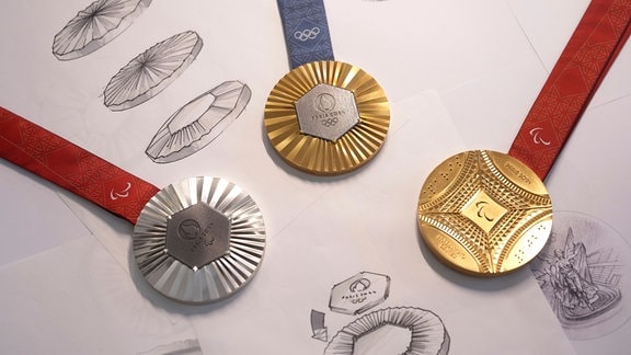 Ein sechseckiges, poliertes Eisenstück vom Eiffelturm wird in jede Gold-, Silber- und Bronzemedaille eingebettet.