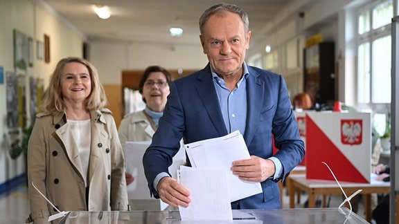 Donald Tusk (r), Ministerpräsident von Polen, und seine Frau Malgorzata Tusk (l) geben ihre Stimmen in einem Wahllokal ab. 