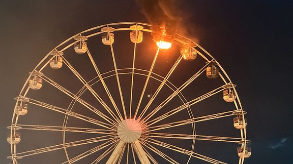 Auf dem Highfield-Festival sind an einem Riesenrad Flammen zu sehen.