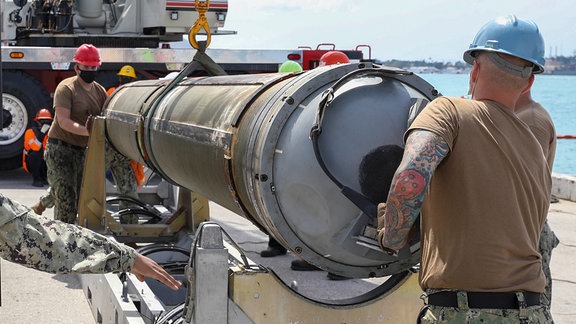 Matrosen des U-Boot-Tenders USS Emory S. Land entladen eine Tomahawk-Rakete