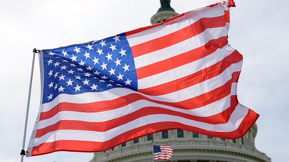 US-Amerikanische Flaggen wehen im Wind vor dem Kapitol in Washington.