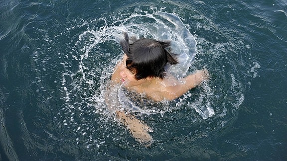 Ein Junge badet im Baggersee.
