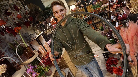 Florist Martin Neumann hält Fahrrad-Felge