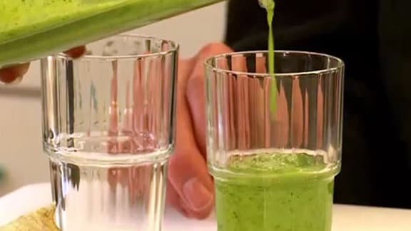 Eine grüne dicke Flüssigkeit wird in ein Glas gegossen.