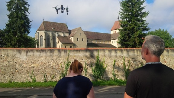 Kamerateam mit Drohne vor Klosteranlage auf Insel Reichenau.