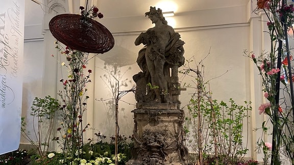 Eine Statue mit Blumenschmuck in der Ausstellung "Dresdner Frühling im Palais"