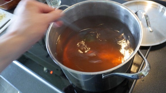 Tee wird in einem Topf gekocht.